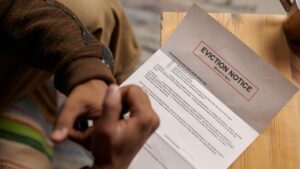 Person reading eviction notice at wooden table