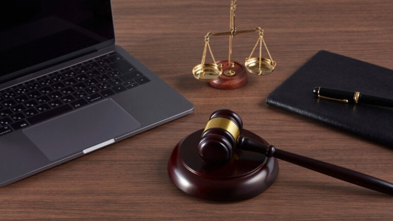 Gavel, laptop, and scales of justice on desk