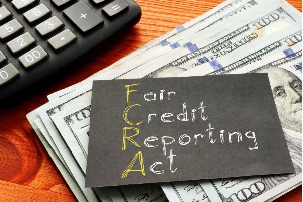 Fair Credit Reporting Act card placed on stack of dollar bills.