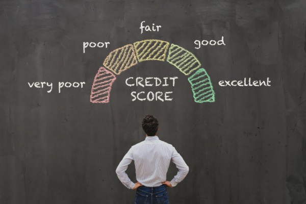 Man looking at chalkboard with credit score range diagram.