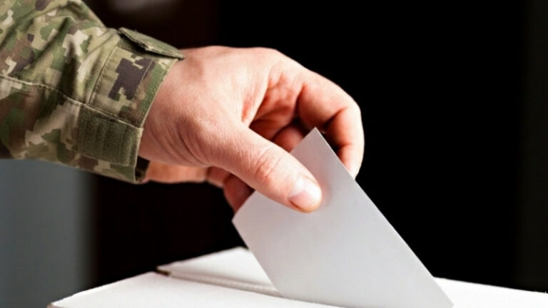 Soldier casting ballot into voting box.