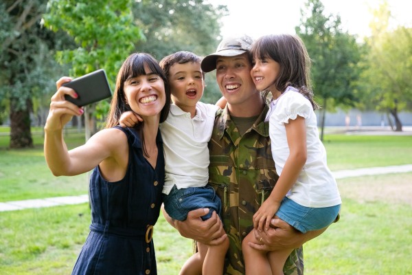 Happy soldier taking selfie with wife and kids