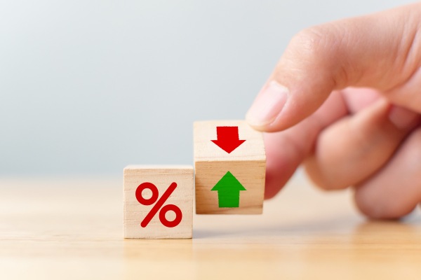 Hand holding wooden blocks with percent arrows
